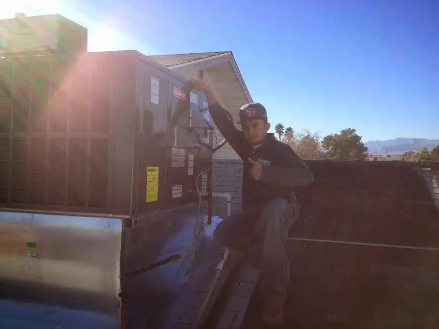 HVAC technician performing HVAC Inspection on a rooftop unit in Headland